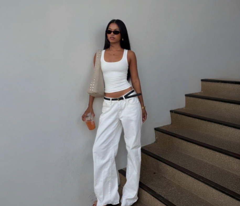 Model wearing all white outfit, with black belt